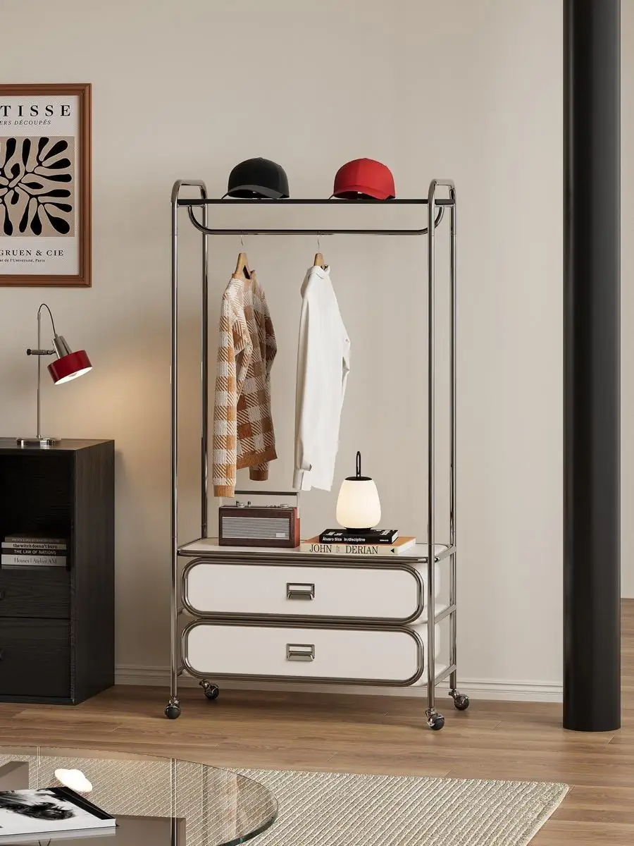 mobile tubular garment rack with drawers shown with surrounding furniture for scale