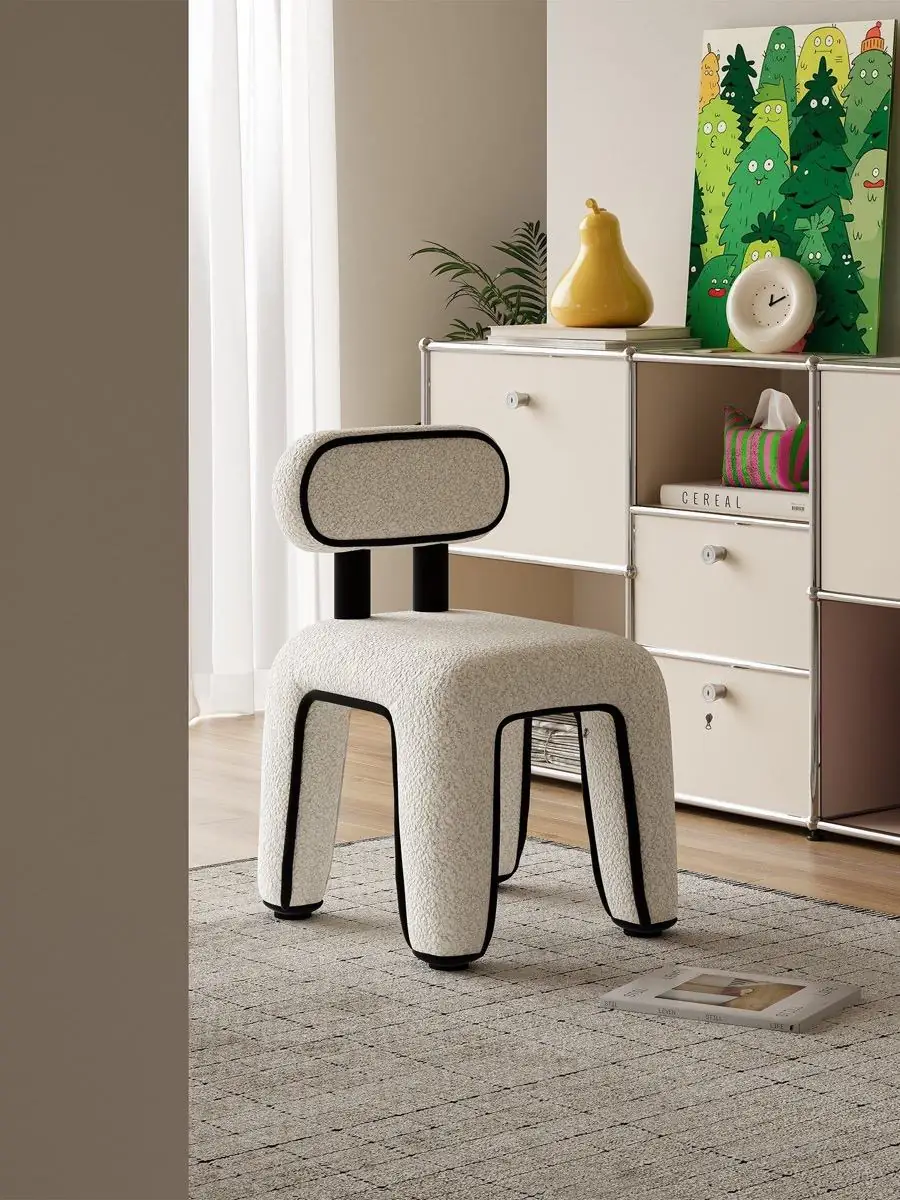 White bouclé accent chair with black piping in a bright living room