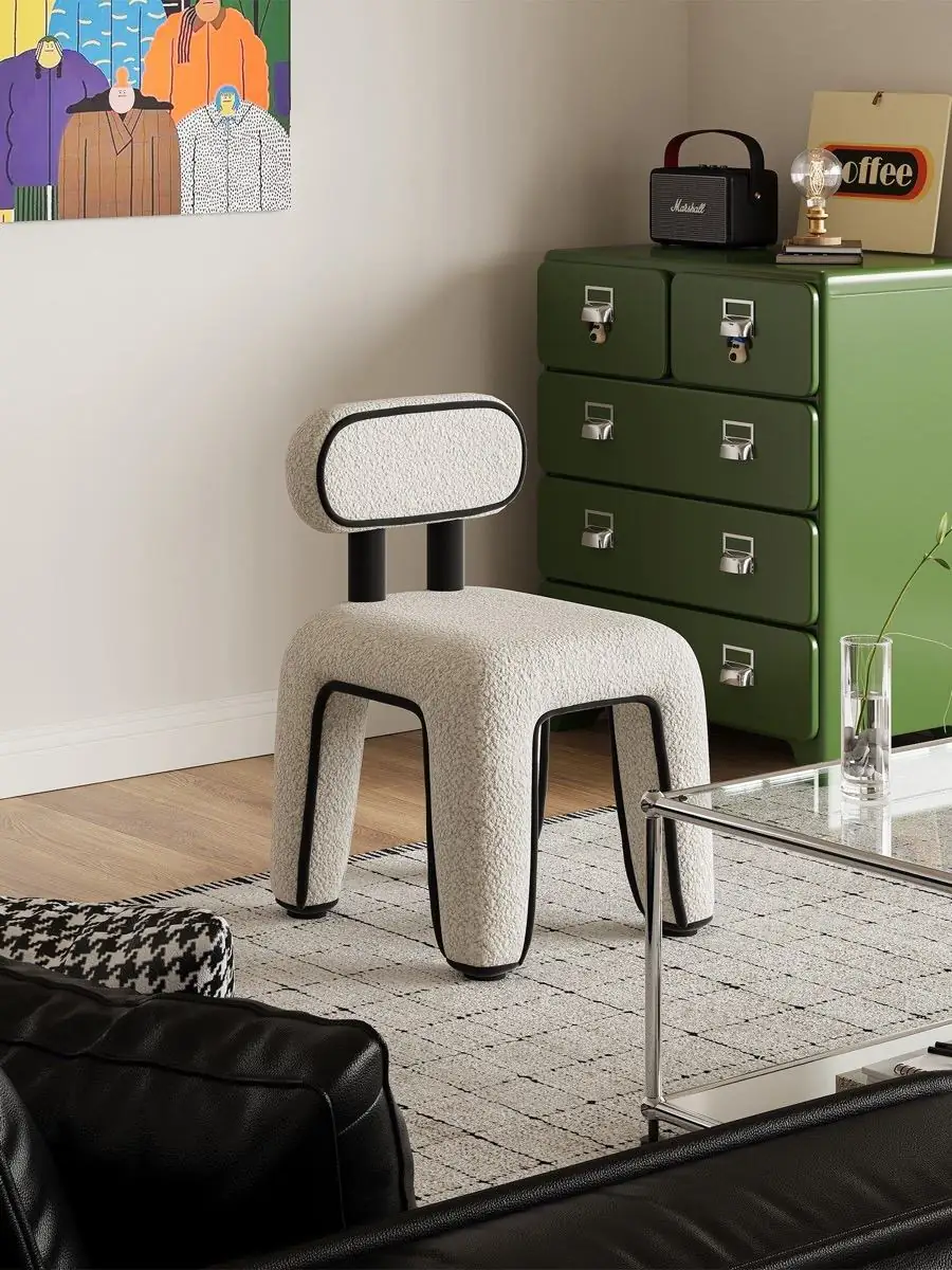 Compact white chair staged against green storage cabinets and wall art