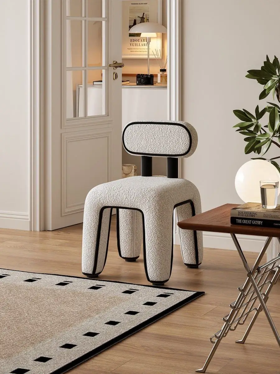 Bouclé chair with outlined legs presented in a contemporary lounge