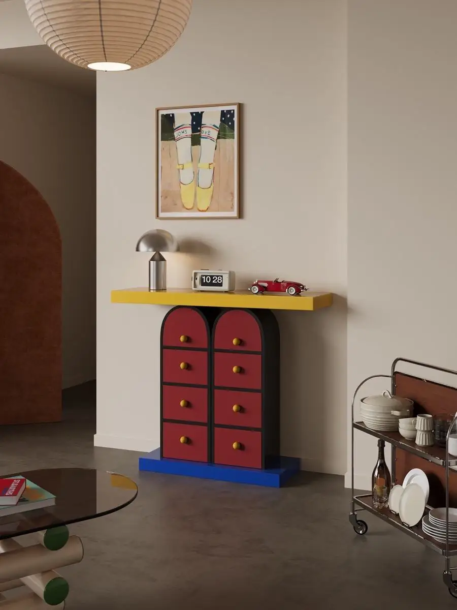 Memphis-style multicolour drawer console shown with surrounding furniture for scale