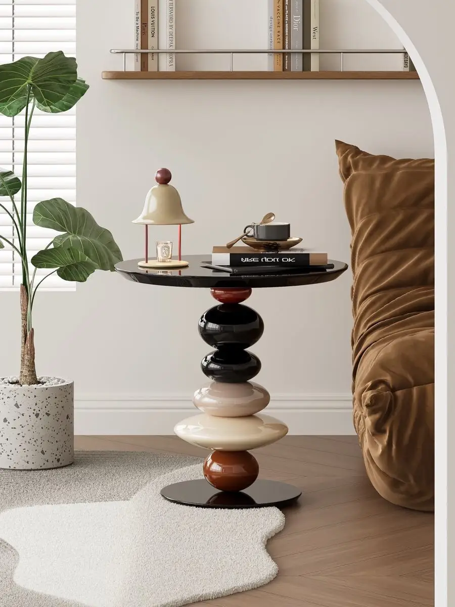 Sculptural side table with stacked glossy black, cream and brown volumes